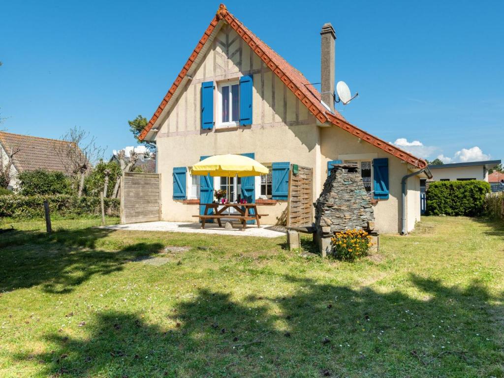 a house with a table and a yellow umbrella at Holiday Home Villa la Fourmi by Interhome in Saint-Germain-sur-Ay
