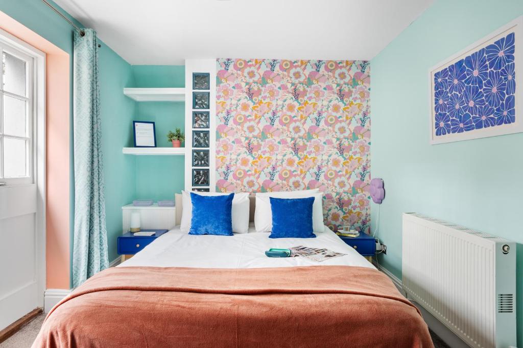 una camera da letto con pareti blu e un letto con cuscini blu di Harbour Court Plymouth - Free Parking - tucked away on the Barbican with courtyard - by Ocean City Retreats a Plymouth