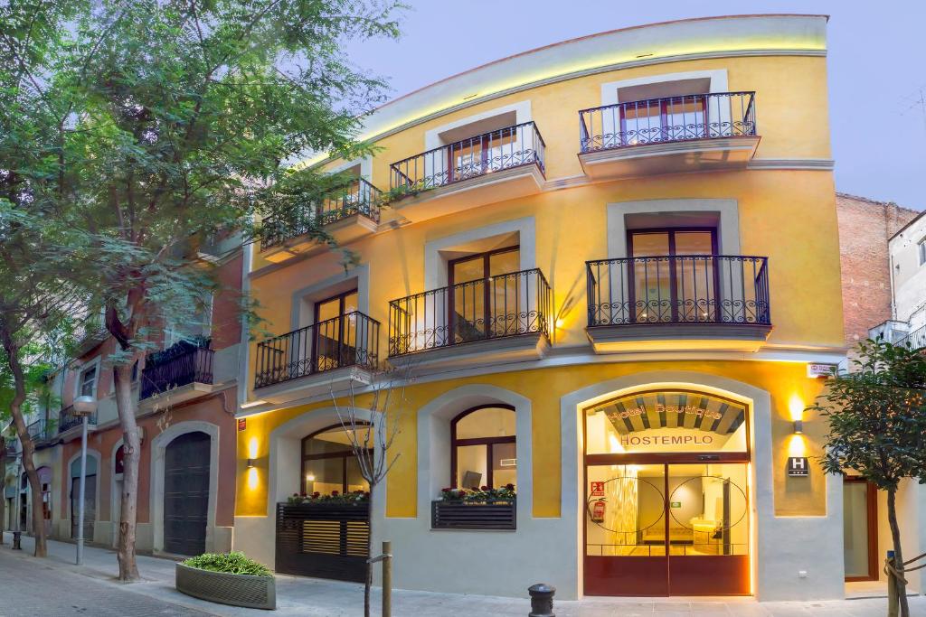 a yellow building with balconies on a street at Boutique Hostemplo Sagrada Familia in Barcelona