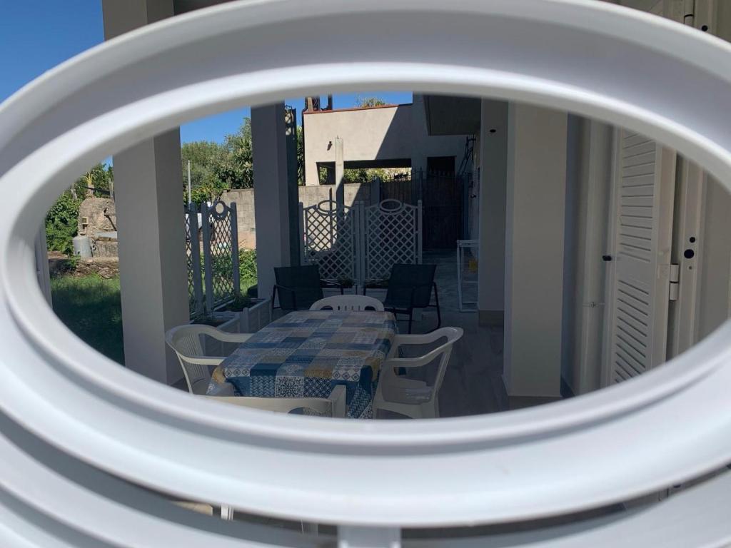 ein Spiegel, der einen Tisch und Stühle auf einem Balkon reflektiert in der Unterkunft Il giglio di mare in Santa Maria di Castellabate