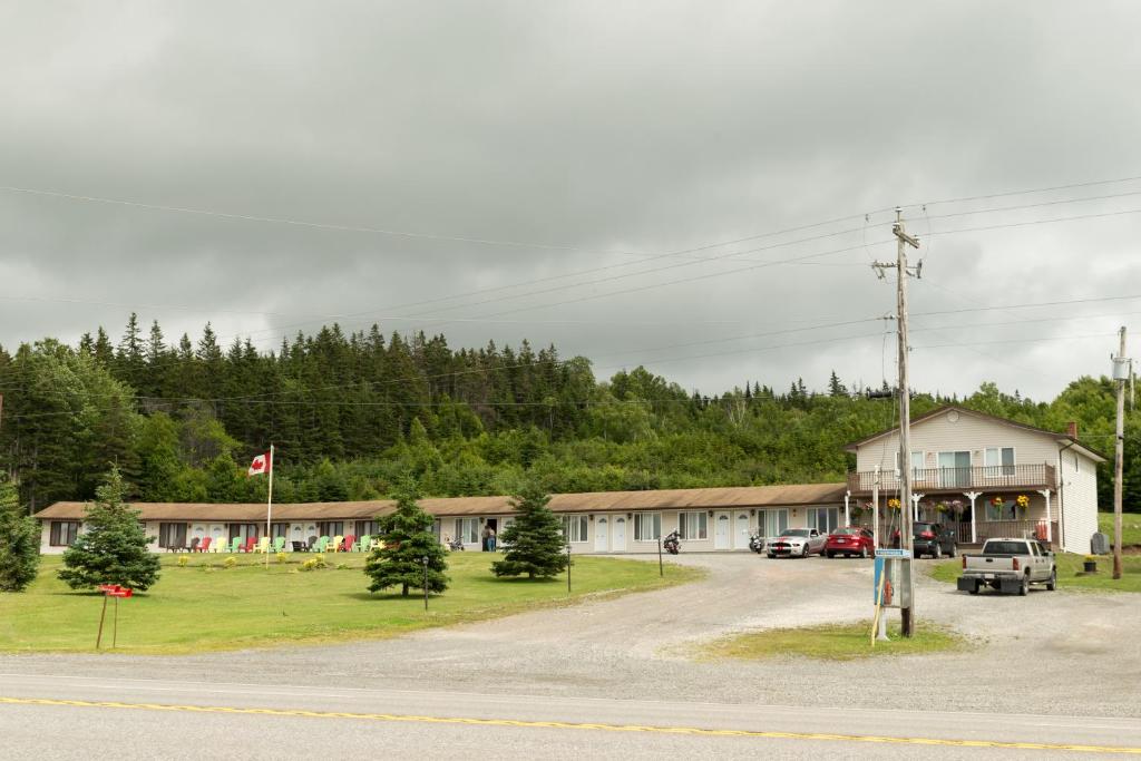 a building with cars parked in a parking lot at Kelly's View Motel in Boularderie East