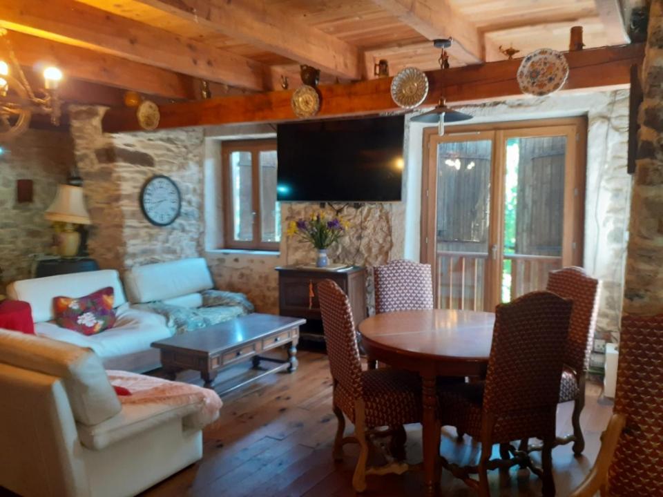 un salon avec une table et un canapé dans l'établissement Maison de montagne rustique, à Castanet-le-Haut