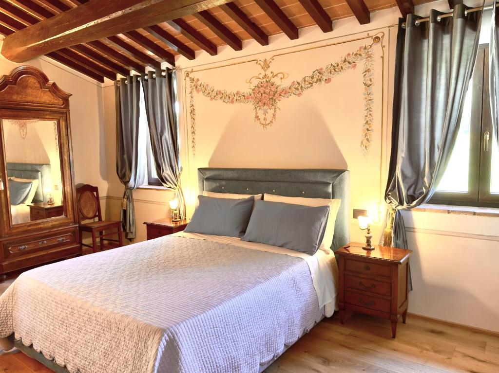 sypialnia z dużym łóżkiem i lustrem w obiekcie Relais Santa Margherita w Arezzo