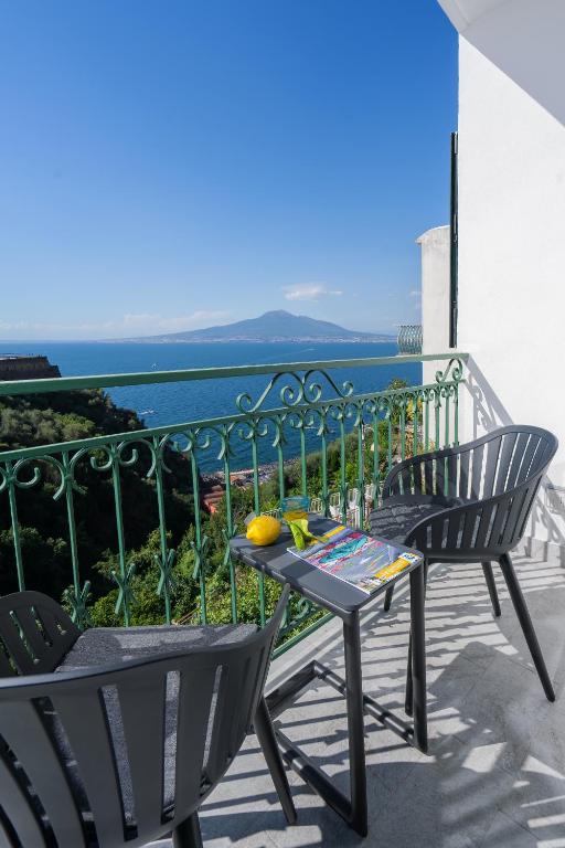 a table and chairs on a balcony with a view of the ocean at Sea View Deluxe Apartments in Vico Equense