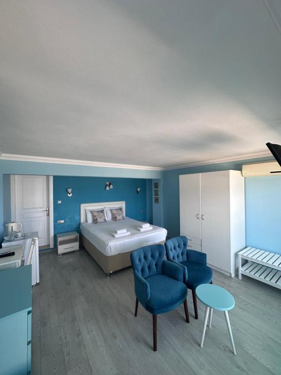 a bedroom with a bed and blue walls at Fener Hotel Café & Kahvalti in Çeşme