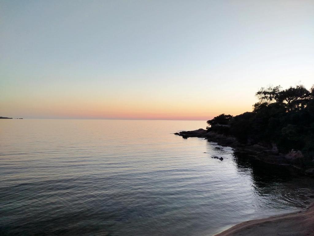 un coucher de soleil sur une masse d'eau dans l'établissement Olmeto 10 mn plage App 5-6P, à Olmeto