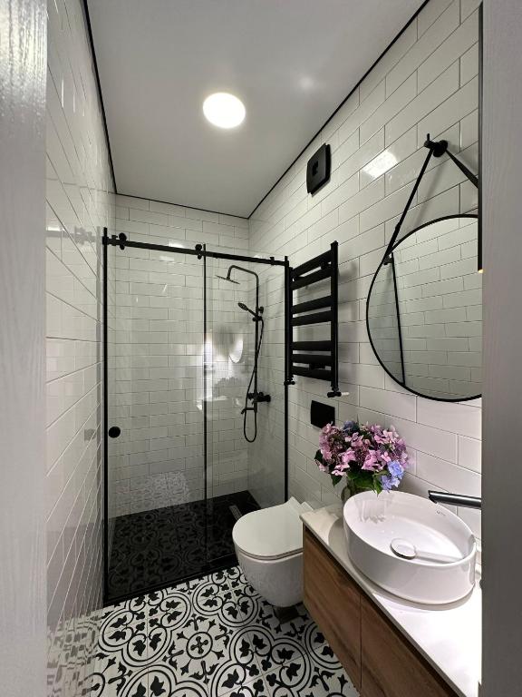 a bathroom with a shower and a toilet and a sink at Home Side Apartment in Batumi