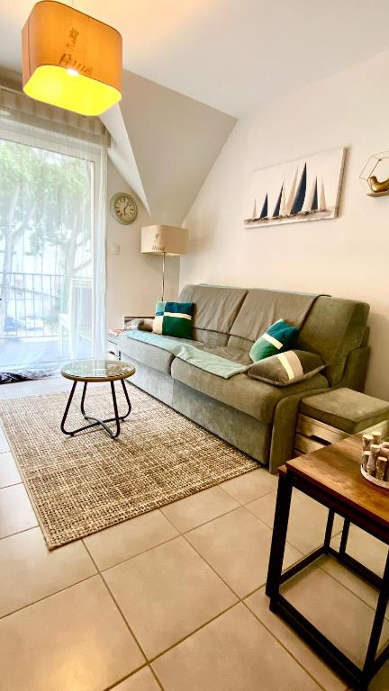 un salon avec un canapé et une table dans l'établissement La Riviera à 50m de la plage, à Bénodet