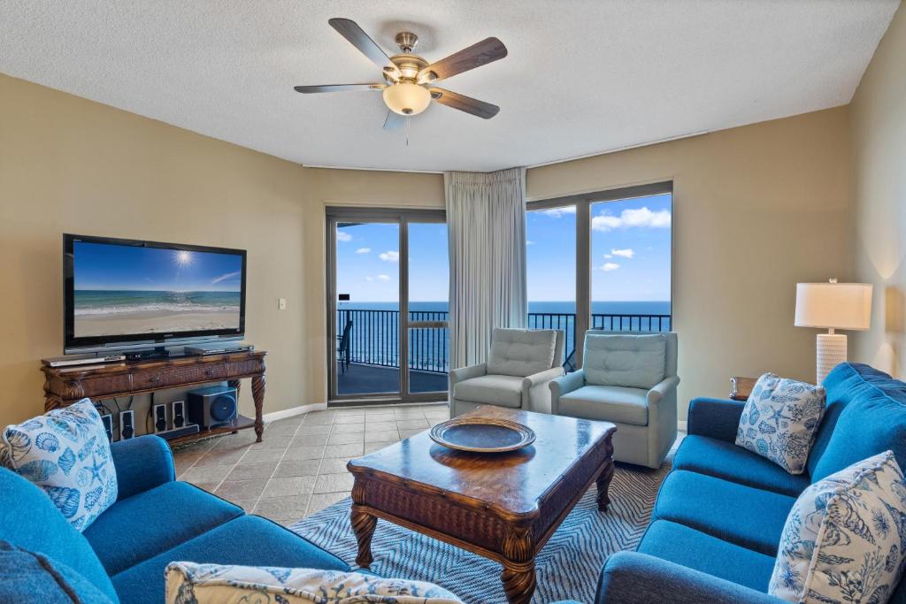 a living room with blue furniture and a flat screen tv at Phoenix 6 Unit 1213 in Orange Beach