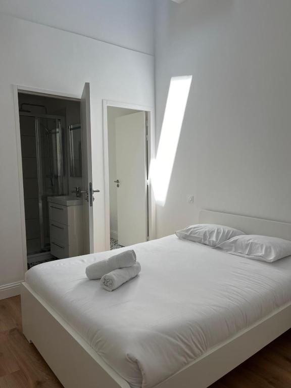 un lit blanc avec deux serviettes dessus dans l'établissement Chambre , hôtel particulier Bordeaux, à Bordeaux