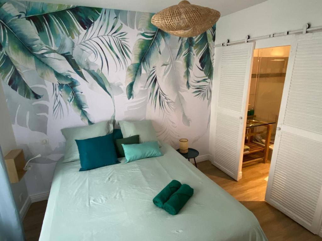 Un dormitorio con una cama con almohadas verdes. en Le Nid Cosy Bordeaux, en Burdeos