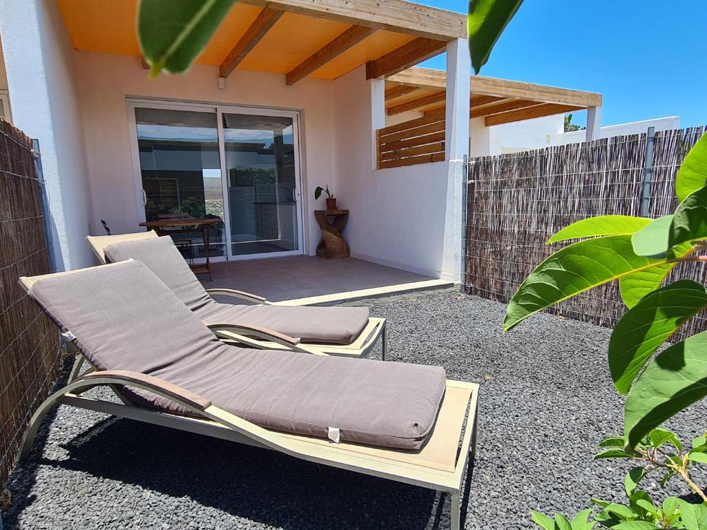 two lounge chairs sitting on a patio in front of a house at Estudio SoleArte en Lajares in Lajares