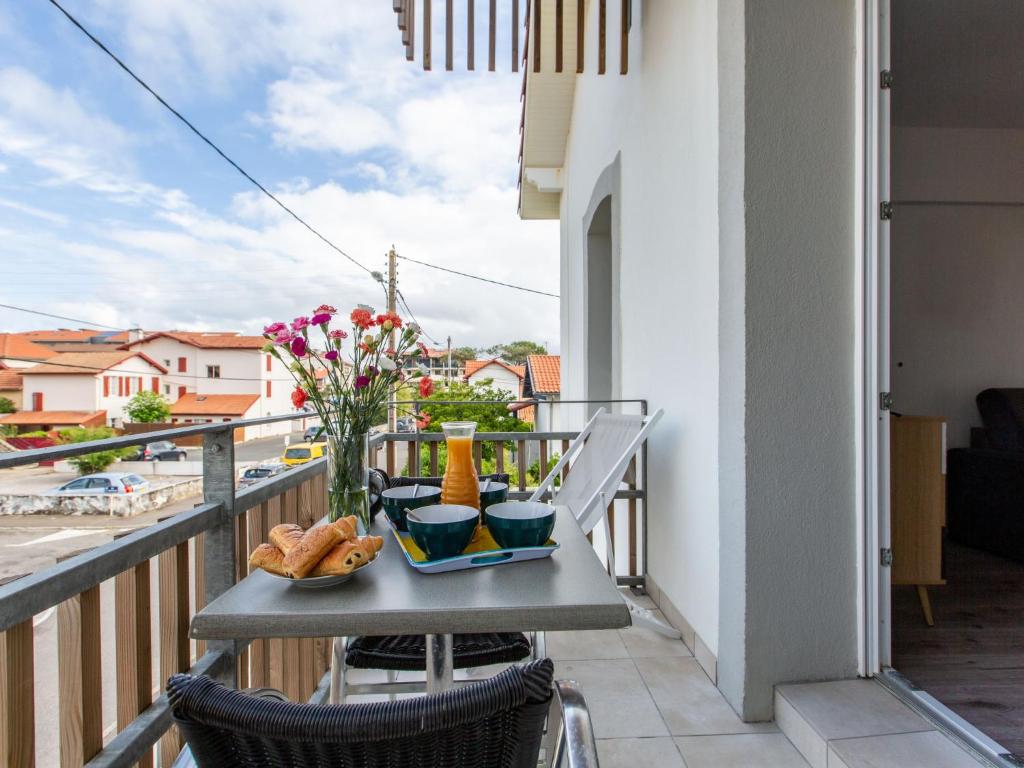 - un balcon avec une table, de la nourriture et des fleurs dans l'établissement Apartment Cap Océan-2 by Interhome, à Capbreton