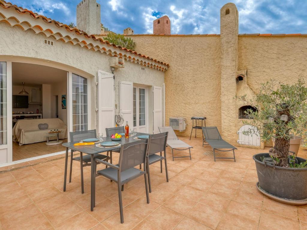 un patio avec une table et des chaises devant une maison dans l'établissement Apartment Hameau la Madrague-28 by Interhome, à Saint-Cyr-sur-Mer