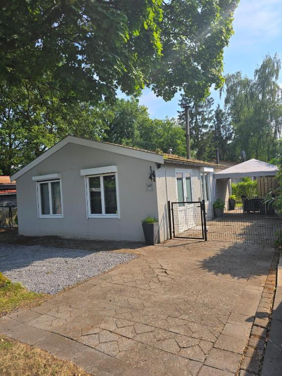 a small white house with a fence at T'chaletje met hottub in Lanaken