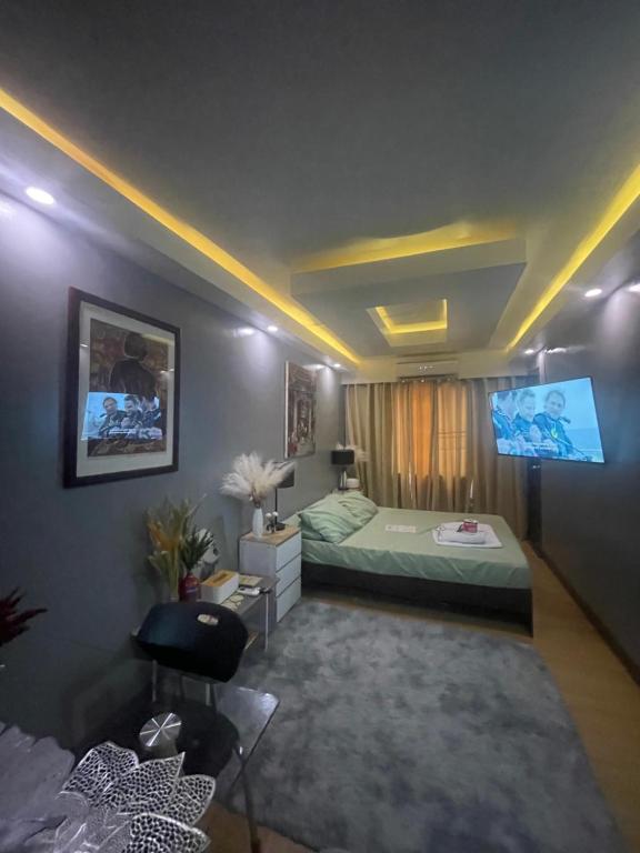 a bedroom with a bed and a flat screen tv at Aura Suite in Imus