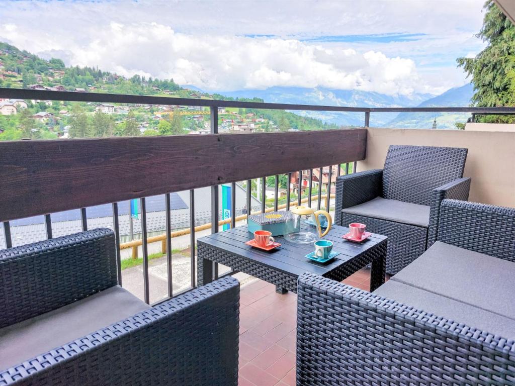 d'un balcon avec des chaises et une table avec des tasses. dans l'établissement Apartment La côte du Parc-1 by Interhome, à Saint-Gervais-les-Bains