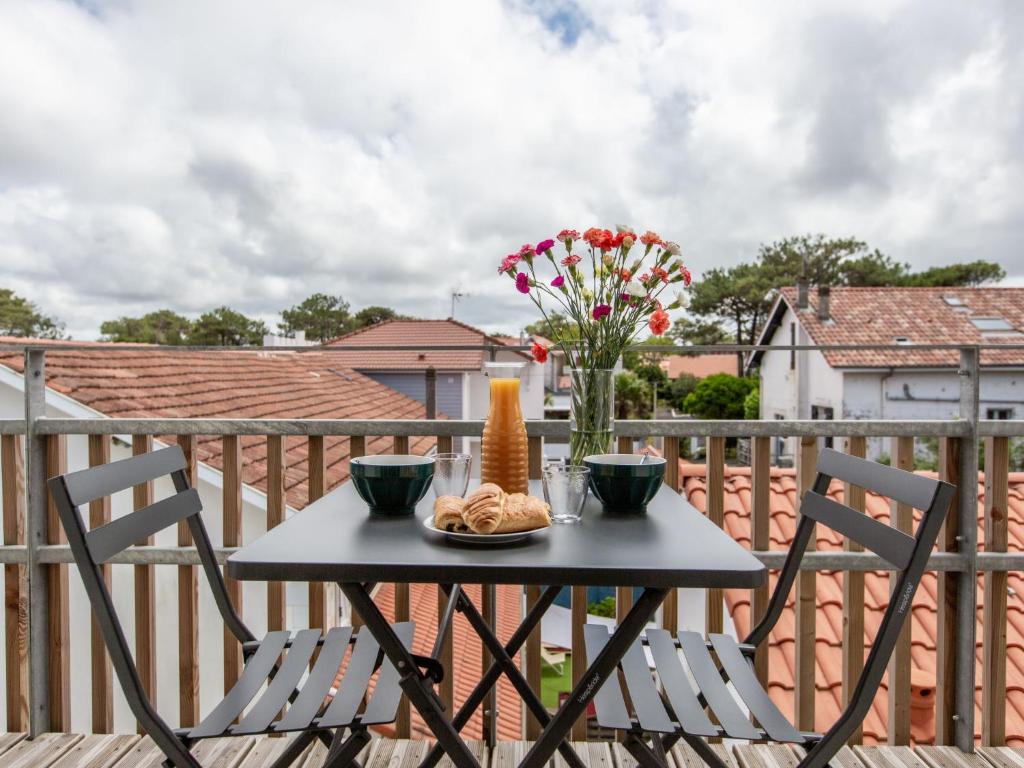 une table avec une assiette de nourriture sur un balcon dans l'établissement Apartment Cap Océan-1 by Interhome, à Capbreton