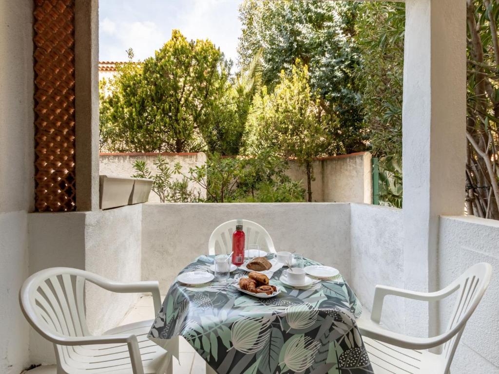 - une table avec une assiette de nourriture sur la terrasse dans l'établissement Apartment Super Plage-4 by Interhome, à Saint-Cyr-sur-Mer