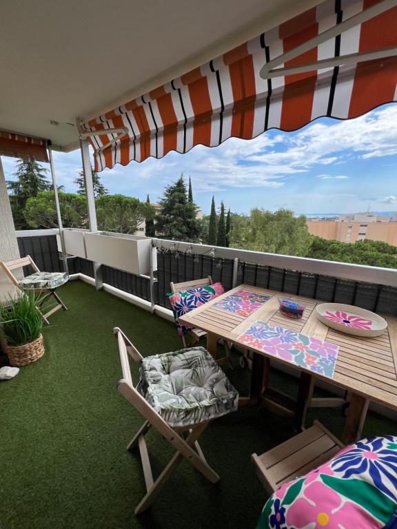 un balcon avec une table, des chaises et un parasol dans l'établissement Appartement Les Oliviers, à Nice