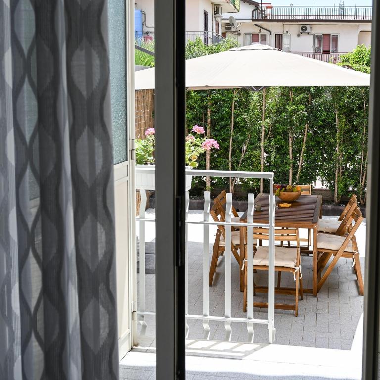 a patio with a table and an umbrella at Casa Aricò in Calatabiano