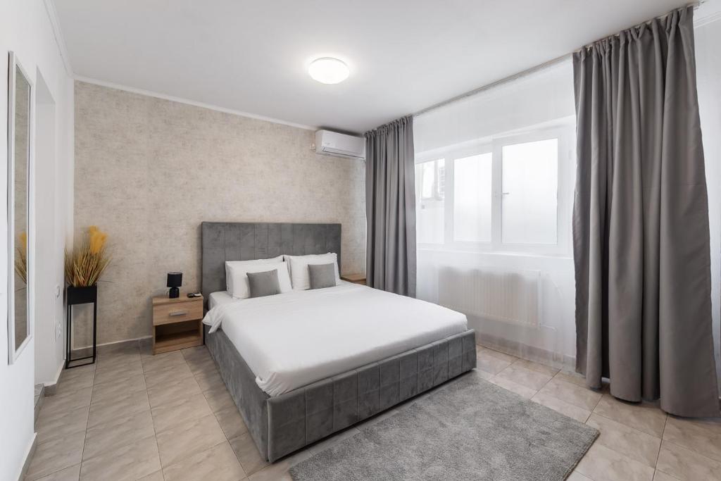 a bedroom with a bed and a large window at Downtown Victoria Studios By CityBookings in Bucharest
