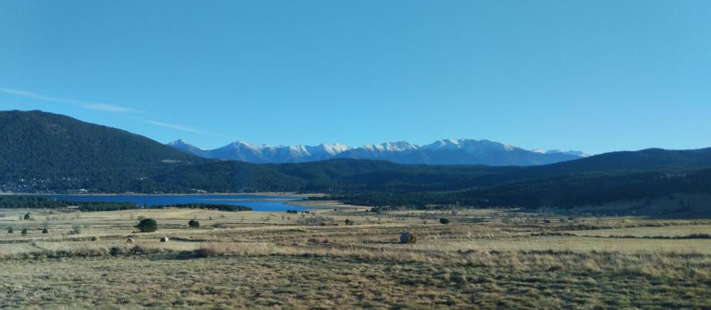 un champ avec une rivière et des montagnes en arrière-plan dans l'établissement Entre FAUNE, LAC et MONTAGNE, aux Angles