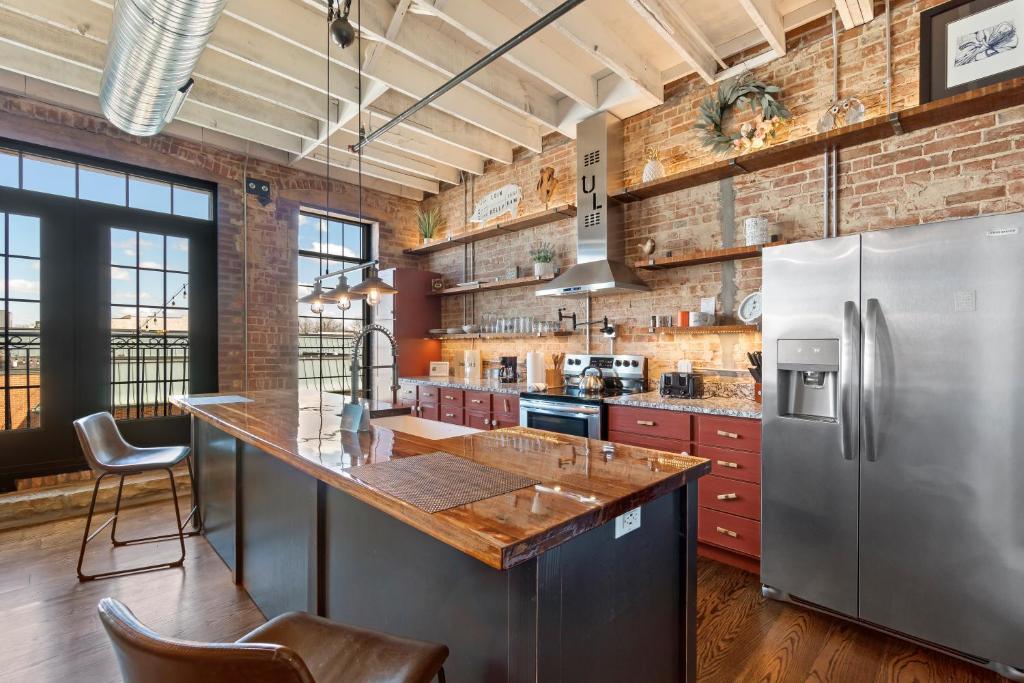 an industrial kitchen with a brick wall and stainless steel appliances at Downtown Urban Loft above Restaurant #7 in Perryville