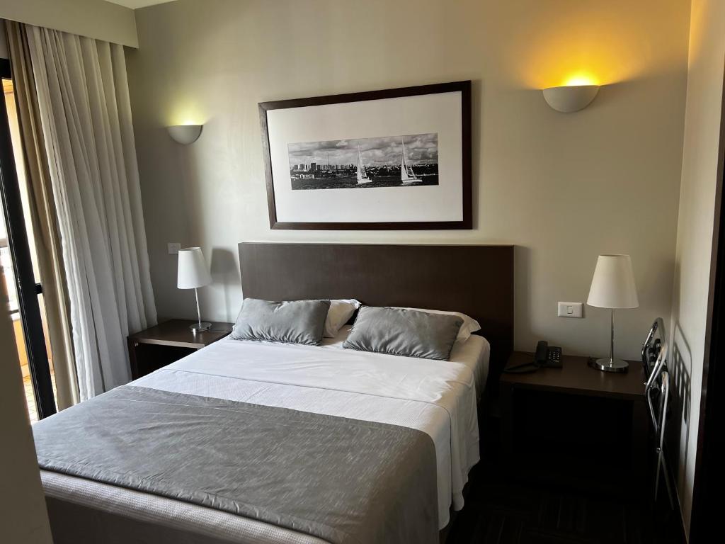 une chambre d'hôtel avec un lit et deux tables de nuit dans l'établissement Hotel Bonaparte Flat Particular B, à Brasilia