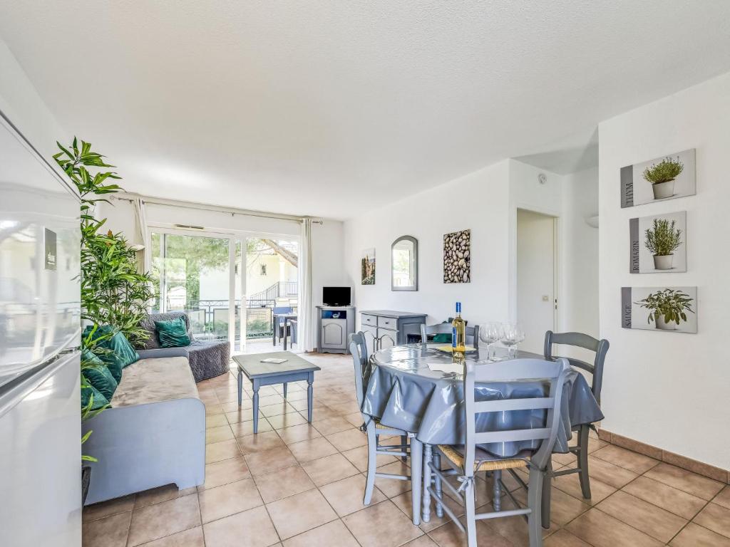 une salle à manger et un salon avec une table et des chaises dans l'établissement Apartment Le Jardin d'Artemis-2 by Interhome, à Saint-Tropez