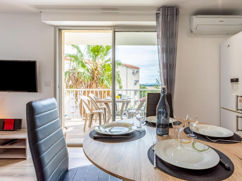 een eetkamer met een tafel en uitzicht op de oceaan bij Apartment Europa by Interhome in Canet-en-Roussillon