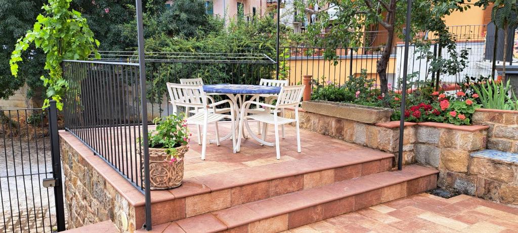 a patio with a table and chairs in a garden at Casa Giulia in Castelbuono