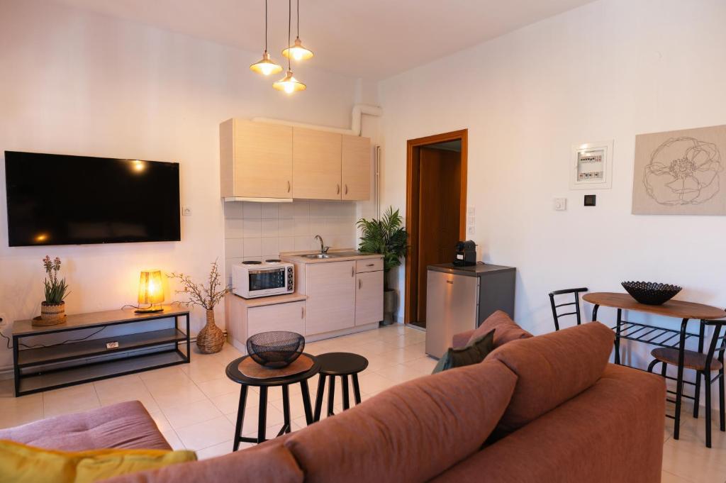 a living room with a couch and a kitchen at Gardens of Babylon by Heaven's Hall in Alexandroupoli