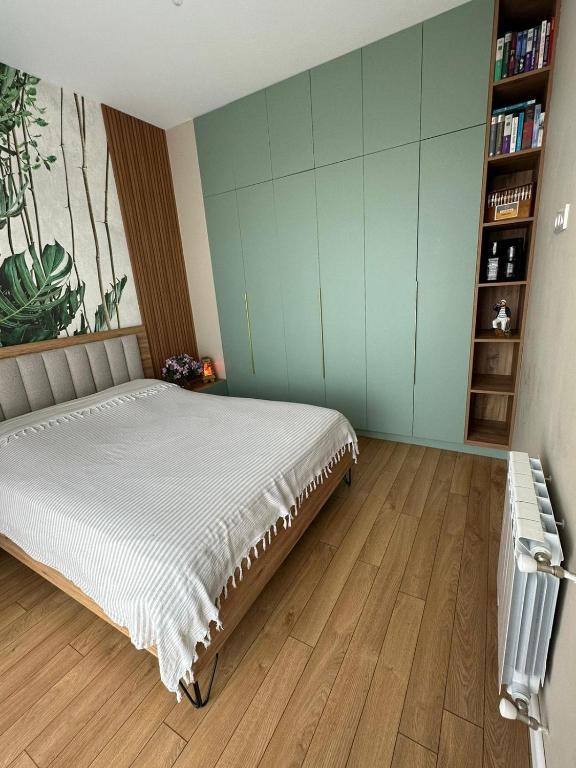 a bedroom with a bed and a book shelf at Home Side Apartment in Batumi
