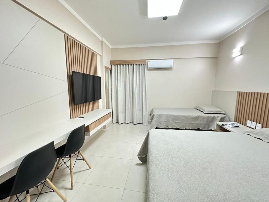 a hotel room with two beds and a flat screen tv at Spazzio diRoma com acesso ao Acqua Park - Luciana in Caldas Novas