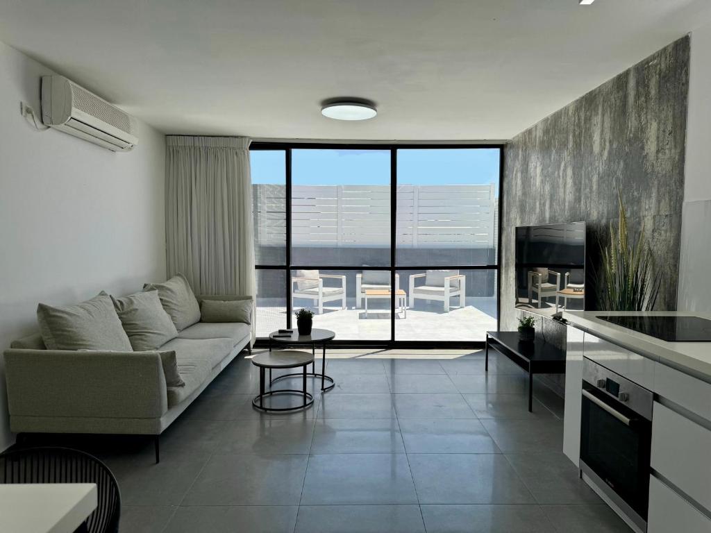 a living room with a couch and a table at מיני דירת פנטהאוז in Rishon LeẔiyyon