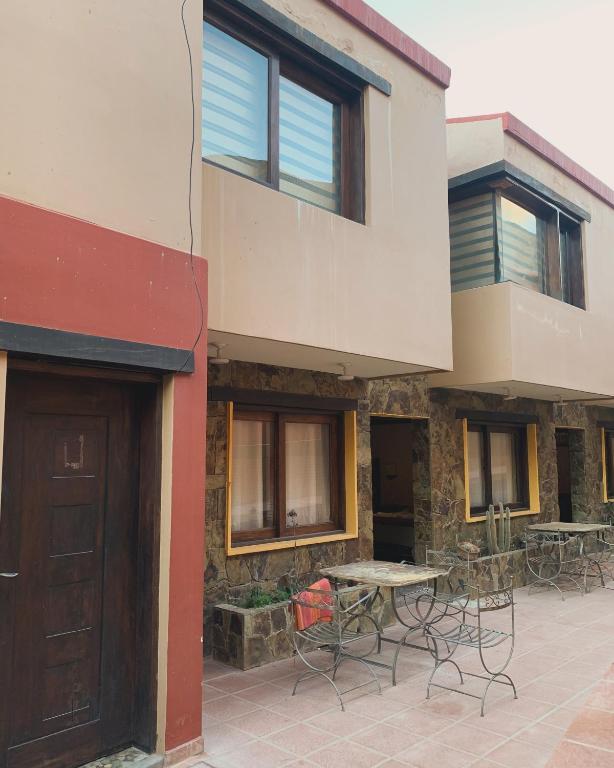 a building with a patio with tables and chairs at Posada Tierra Adentro 2 in Purmamarca