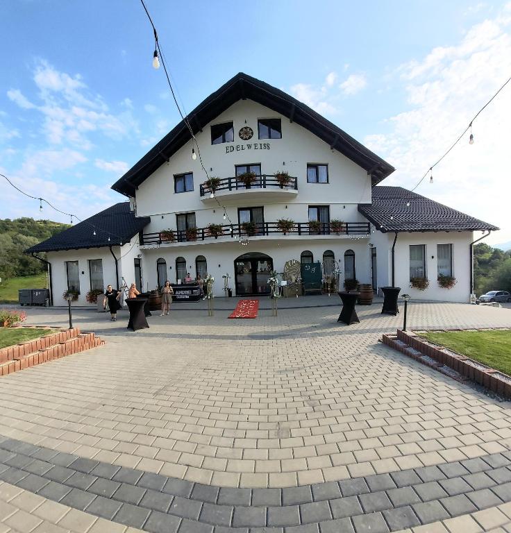 a large white building with a black roof at Evenimente Edelweiss in Bogdan Vodă