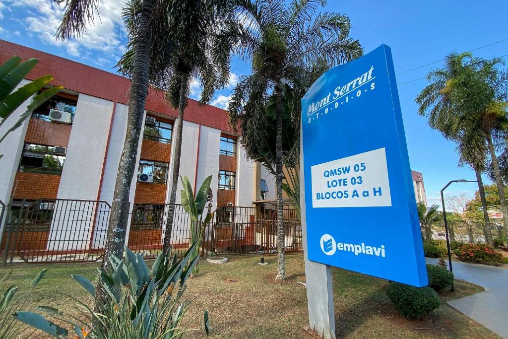 a blue sign in front of a building at OZPED Flats Particulares Condomínio Mont Serrat in Brasilia