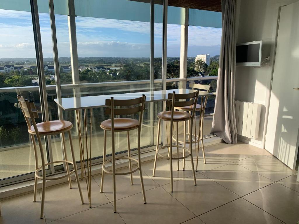 a table and chairs on a balcony with a view at T1 bis neuf avec petite chambre à 150m de la plage in La Baule