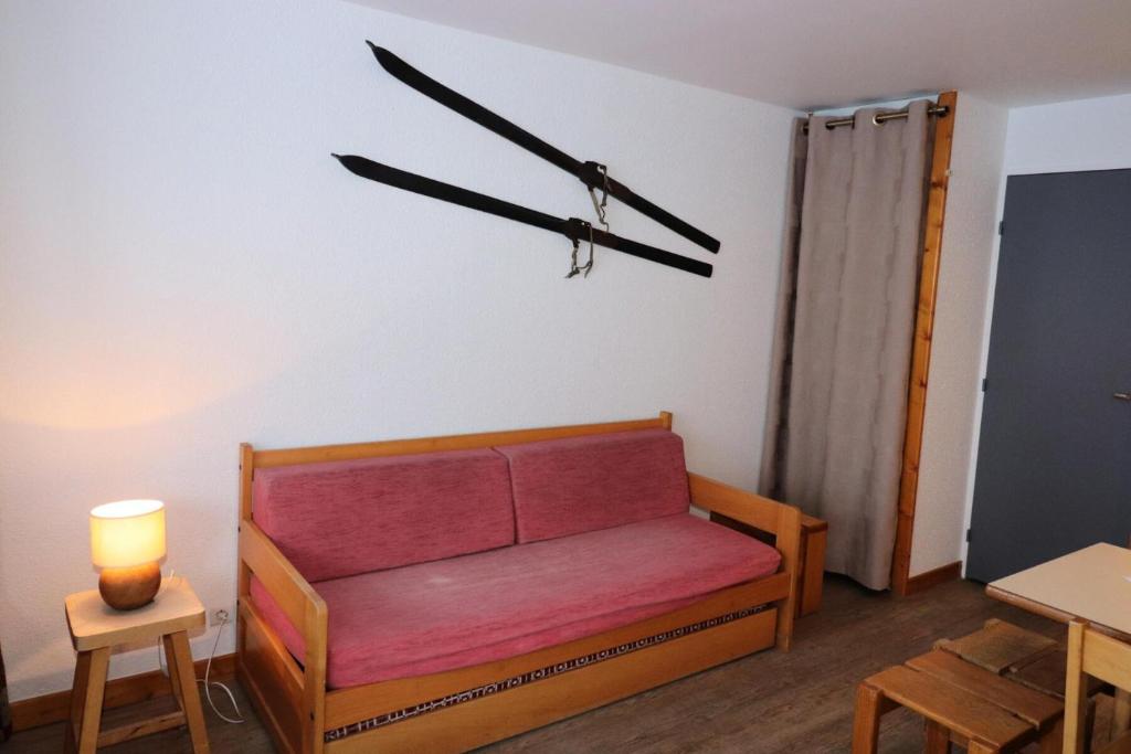 une chambre avec un canapé et un réveil sur le mur dans l'établissement Résidence Home Club - Studio confortable · Proche pistes et commerces MAE-0764, à Tignes