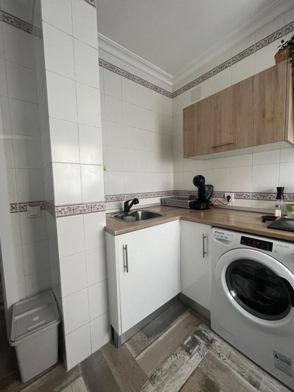 een keuken met een wasmachine en een wastafel bij Lovely Rooms en piso compartido in Sevilla