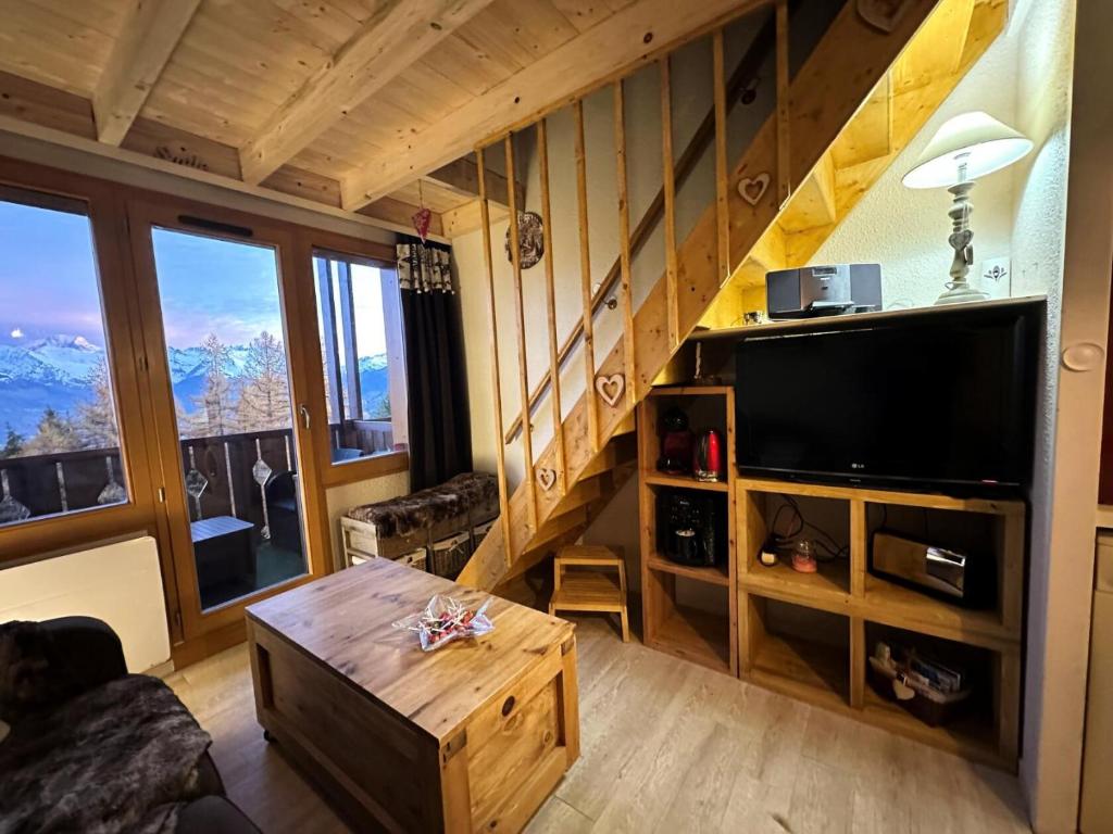 un salon avec une grande télévision et une table dans l'établissement Résidence Le Bilboquet - Magnifique appartement en duplex MAE-2681, à Aime La Plagne