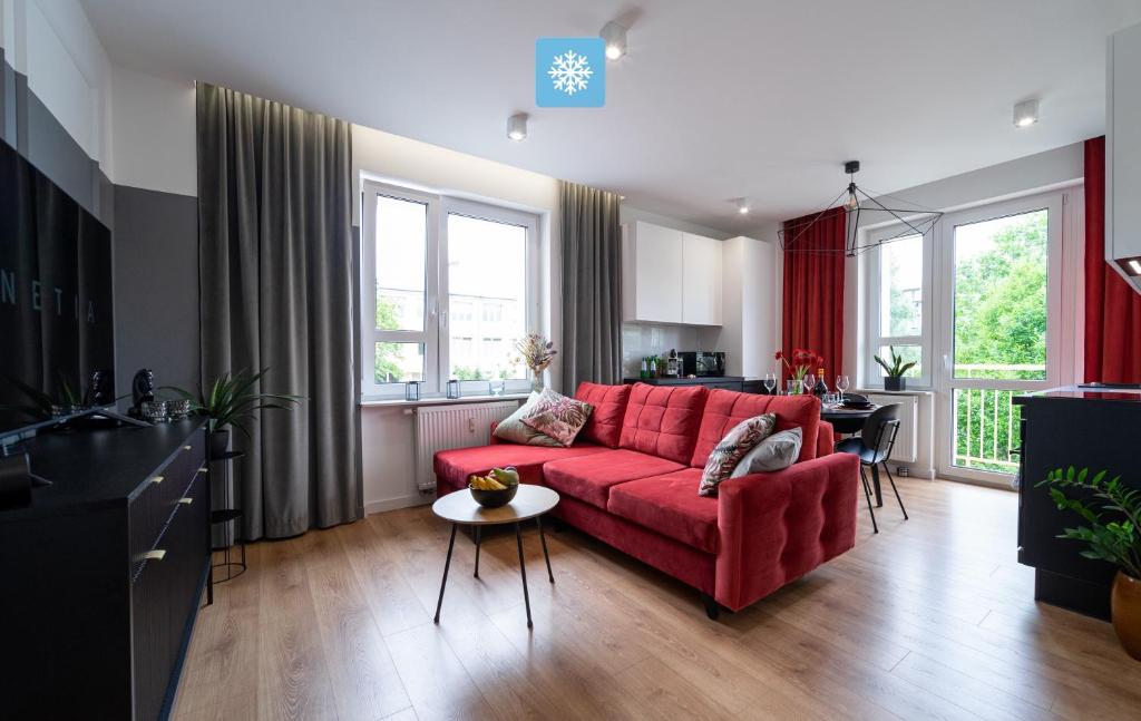 a living room with a red couch and a table at FLATMORE Apartament Długa 8m6 in Zielona Góra