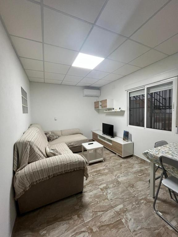 a living room with a couch and a tv at Casa MARISA in Águilas