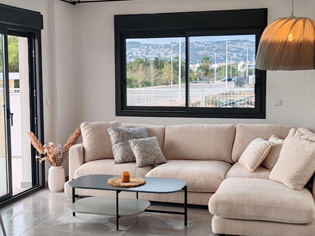 a living room with a couch and a table at Apartamentos Arenal 2 in Jávea
