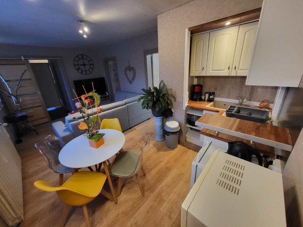 une cuisine et un salon avec une table et des chaises dans l'établissement Au ptit bonheur comtois, à Rosières-sur-Barbèche