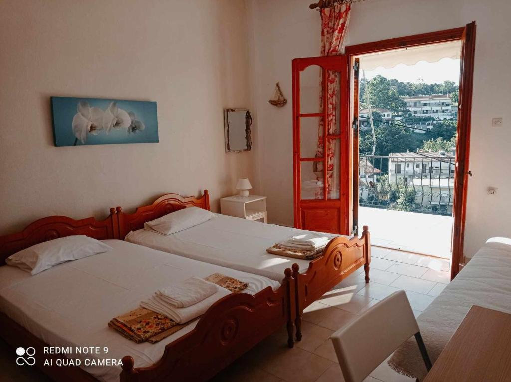 a bedroom with two twin beds and a window at Kandilari Apartments in Kókkinon Nerón