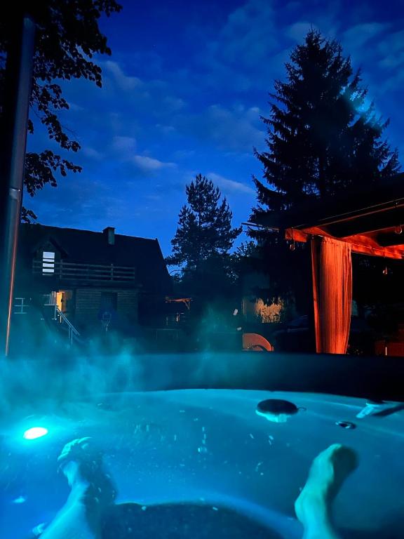 a hot tub in a backyard at night at Malinowa Chata- Królowy Most in Królowy Most