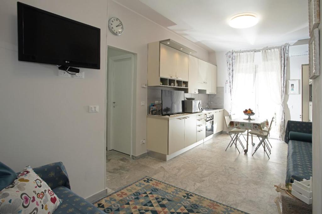 una cucina e un soggiorno con TV a parete di Casa Lux ampio monolocale ad Alassio